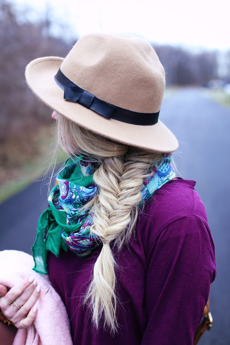 Abby wears a pink coat and a fishtail braid