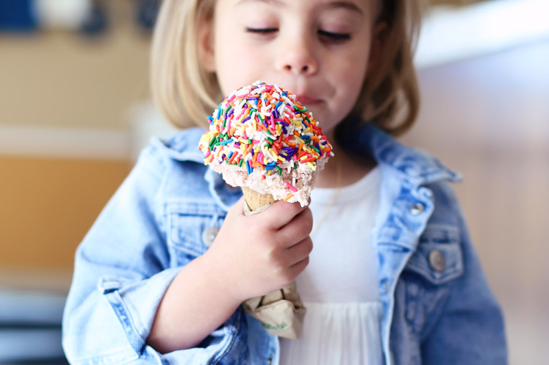 Savy eyes her ice cream cone, covered in sprinkles.