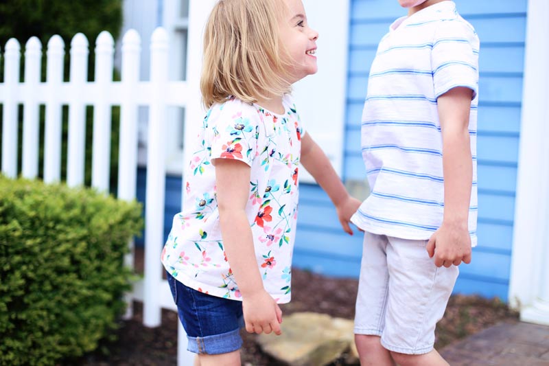 Savy grins as she reaches for her brother's hand.