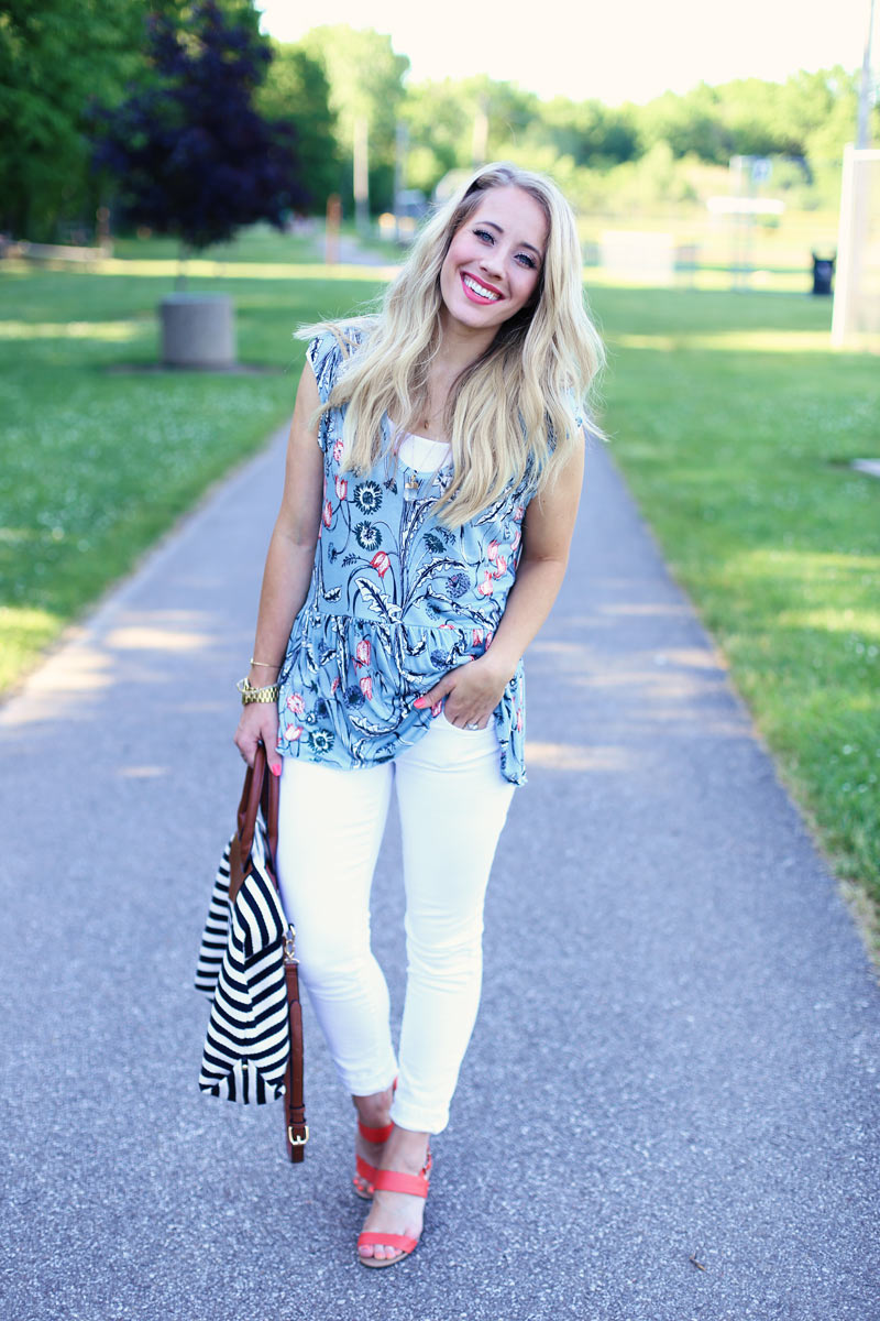 White pants, floral blue top, and coral sandals.