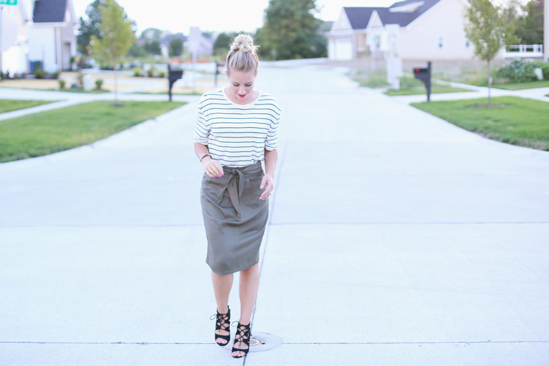 Abby walks down the road wearing a grey skirt, white striped top, and strappy sandals. Twist Me Pretty. Sunday Style.