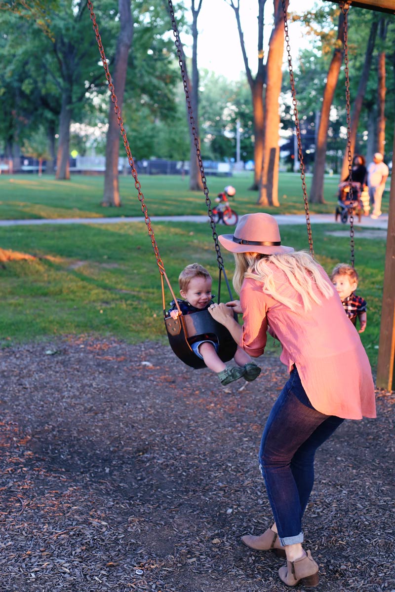 Abby pushes her babies in the swings in a park.