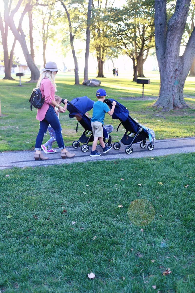 Abby walks behind as Savy and Boston each push one of the twins in a baby jogger stroller.