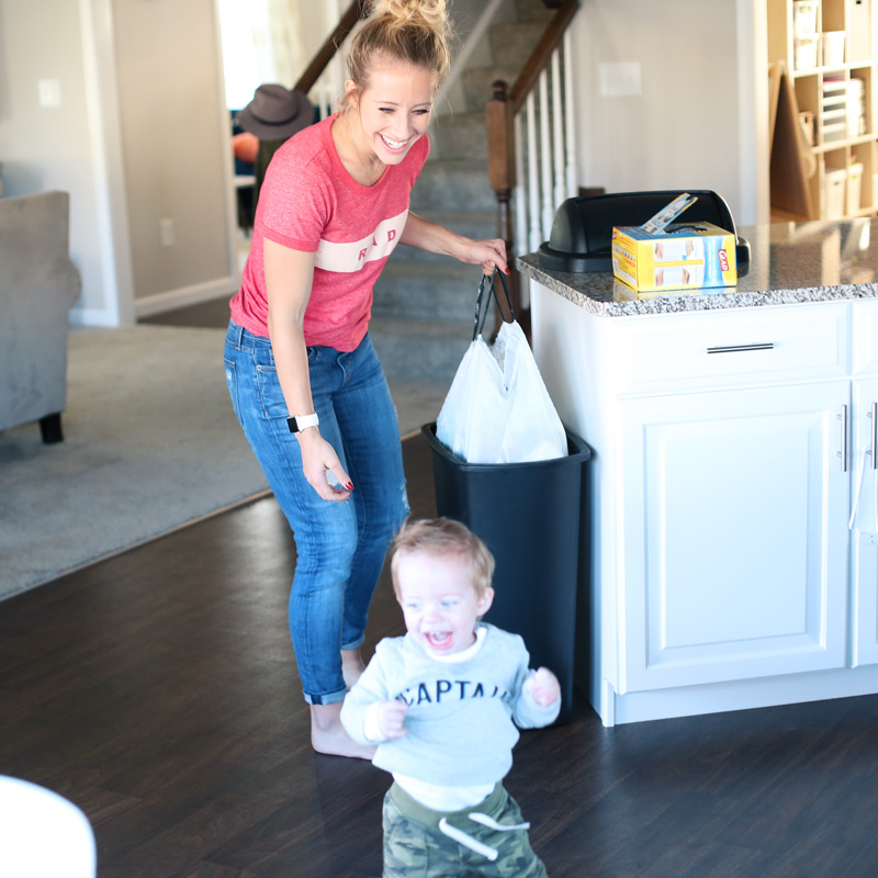 How to keep a clean kitchen? A toddler runs away from his smiling mother.