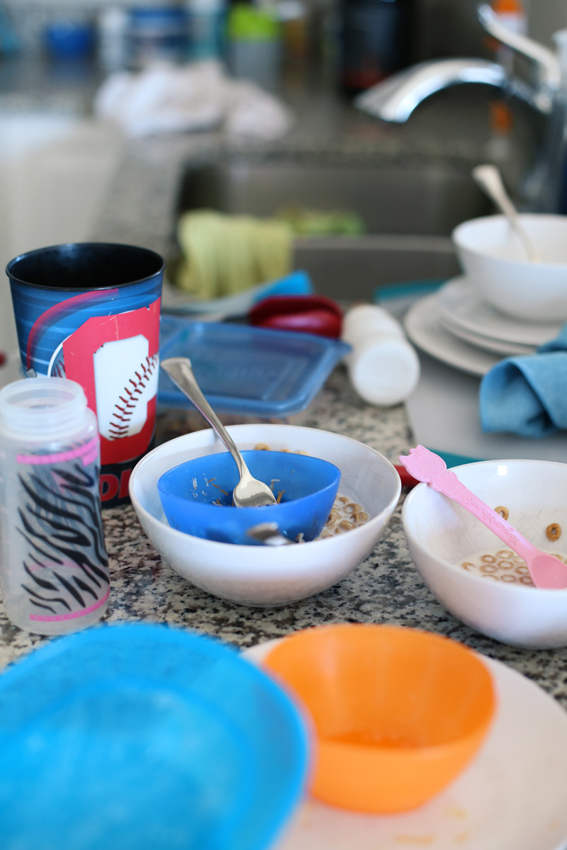 Several used dishes sit on a counter next to a sink in the background.