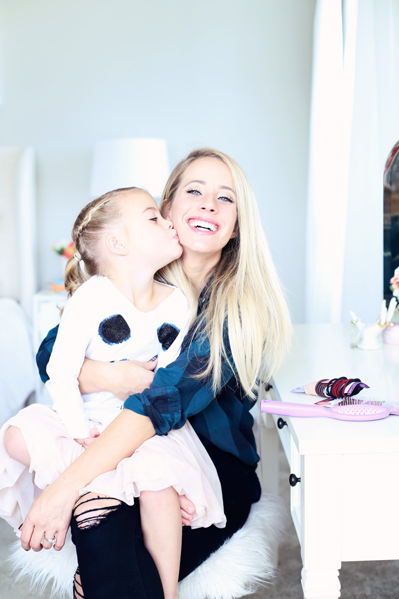 Special moments. A daughter sits on her mother's lap and kisses her on her cheek. Twist Me Pretty - Our Morning Routine.