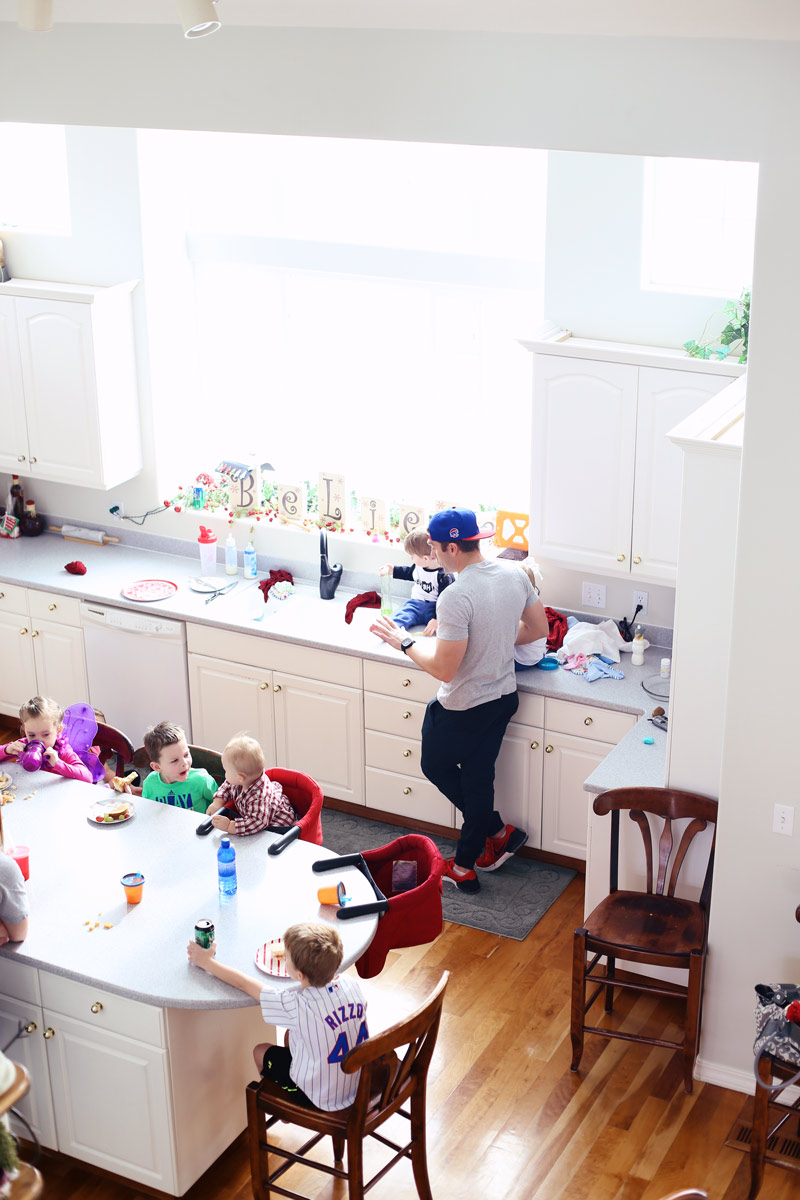 Aerial photo of a beautiful white kitchen, with several children sitting around a table.