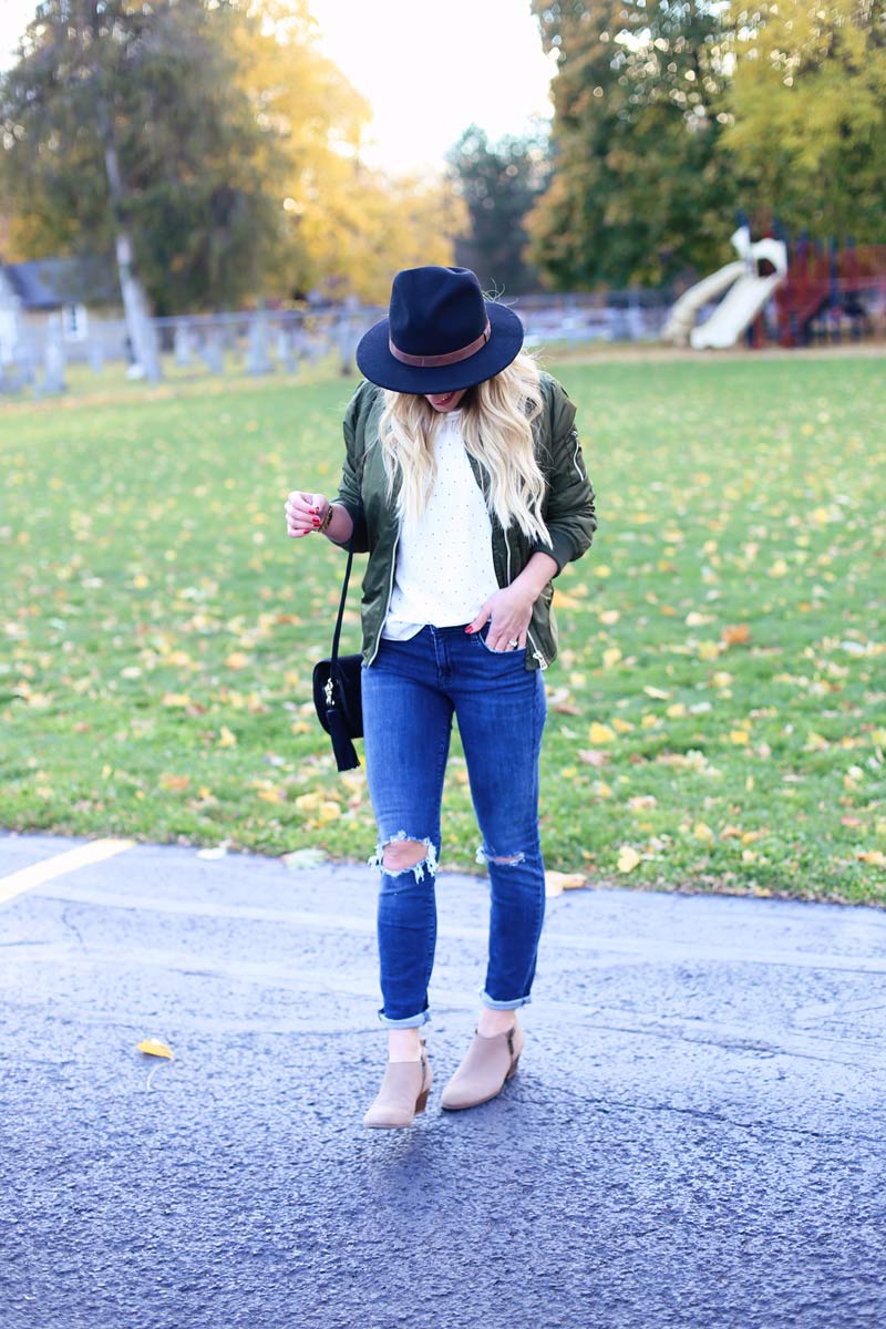 Twist Me Pretty's Abby wears stylish torn jeans, tan booties, and a hat.