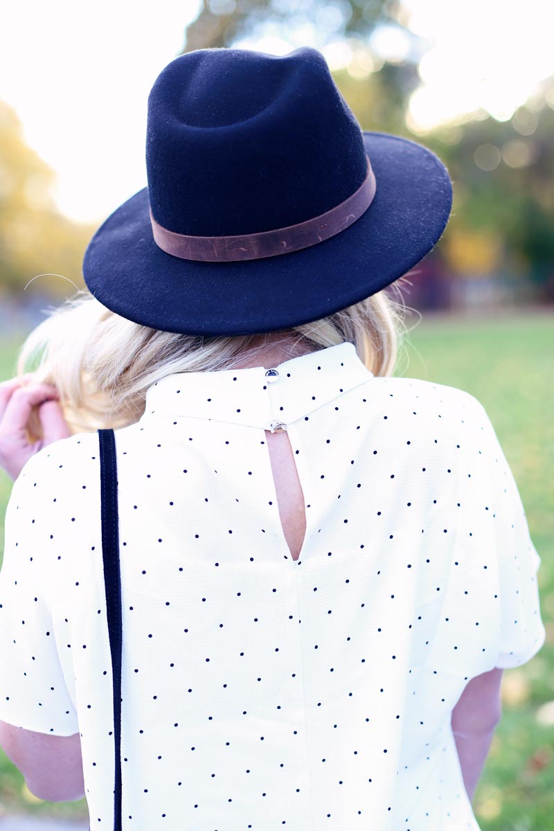 A black hat paired with a white, polka dot shirt - pretty.